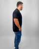 Man wearing a black t-shirt and blue jeans on a gray background